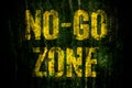 Ã¢â¬ÅNo-Go ZoneÃ¢â¬Â warning sign in yellow letters painted over dark grungy concrete wall with moss